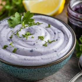 Freshly made Blue Jam Garlic Aioli in a small ceramic bowl, with a creamy texture and purple tint, showcasing the unique flavors of the Blue Jam Garlic Aioli Recipe.