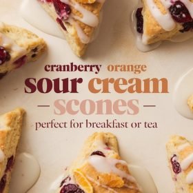 Cranberry orange sour cream scones served with a side of fresh whipped cream and jam.
