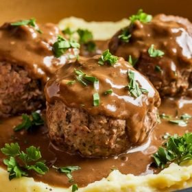 Comforting crockpot Salisbury Steak Meatballs paired with creamy mashed potatoes and steamed vegetables